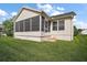 Rear exterior view of a home with a screened porch and well-maintained lawn at 1318 Guerra Ave, The Villages, FL 32159