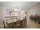 Dining room featuring a modern chandelier, wood floors, and views into the kitchen at 1318 Guerra Ave, Lady Lake, FL 32159