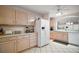 Well-lit kitchen boasts tile flooring, wood cabinets, and modern white appliances at 1318 Guerra Ave, The Villages, FL 32159