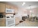 Cozy kitchen with white appliances, white cabinetry and a breakfast nook at 1318 Guerra Ave, The Villages, FL 32159