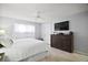 Bright bedroom features wood floors, modern dresser, and a flat screen television at 1318 Guerra Ave, The Villages, FL 32159