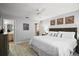 Comfortable main bedroom with a large bed, ceiling fan, wood floors and ensuite bathroom at 1318 Guerra Ave, The Villages, FL 32159