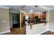 Contemporary kitchen with wooden cabinets, stainless steel refrigerator, and bar-style counter looking into living area at 14049 Fairway Island Dr # 118, Orlando, FL 32837