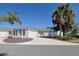 Charming single-story home features an attached garage, a well-manicured lawn, and beautiful palm trees at 1451 Rosedale Way, The Villages, FL 32162