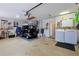Spacious garage with a golf cart, ample storage, and convenient laundry area at 1451 Rosedale Way, The Villages, FL 32162