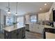 Modern kitchen featuring an island with seating, white cabinets, and stainless steel appliances at 1451 Rosedale Way, The Villages, FL 32162