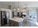 Open floor plan with kitchen island flowing into a living room with fireplace and sliding glass doors at 1451 Rosedale Way, The Villages, FL 32162