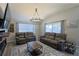 Living room featuring a fireplace, large windows, comfortable seating, and modern chandelier at 1451 Rosedale Way, The Villages, FL 32162
