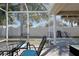 Screened-in patio offering a shaded outdoor space, perfect for relaxation and enjoying the backyard view at 1451 Rosedale Way, The Villages, FL 32162