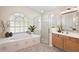 Bright bathroom featuring a soaking tub, a separate glass shower, and a vanity at 14624 Pine Lake St, Clermont, FL 34711
