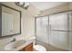This is a bathroom with a mirror over the sink and frosted sliding doors to the shower and toilet at 14624 Pine Lake St, Clermont, FL 34711