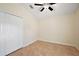 Neutral bedroom featuring tile flooring, a ceiling fan, and a double-door closet at 14624 Pine Lake St, Clermont, FL 34711