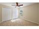 This is a bedroom with tile flooring, a ceiling fan, a window and a closet with double doors at 14624 Pine Lake St, Clermont, FL 34711