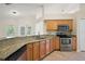 Well-equipped kitchen featuring granite countertops, stainless steel appliances, and light wood cabinetry at 14624 Pine Lake St, Clermont, FL 34711