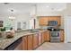 Well-lit kitchen featuring stainless steel appliances and granite countertops at 14624 Pine Lake St, Clermont, FL 34711