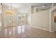 Spacious open-plan living area featuring tile floors, high ceilings, and elegant chandelier lighting at 14624 Pine Lake St, Clermont, FL 34711