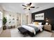 Stylish main bedroom featuring a modern accent wall, tray ceiling, and ceiling fan at 14624 Pine Lake St, Clermont, FL 34711