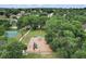 Aerial view of a community playground with mature trees, slides and swings, providing a recreational space for families at 14624 Pine Lake St, Clermont, FL 34711