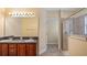 Bathroom featuring double sinks, wooden cabinets, and a glass enclosed shower at 16608 W Citrus Pkwy, Clermont, FL 34714