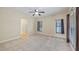 Bright bedroom featuring carpet, ceiling fan, and ample natural light from large windows at 16608 W Citrus Pkwy, Clermont, FL 34714