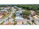 An elevated view of a modern two-story home with a well-manicured lawn, mature trees, and attached two-car garage at 16608 W Citrus Pkwy, Clermont, FL 34714
