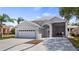 Beautiful home exterior featuring a two-car garage, attached carport, and manicured landscaping at 16608 W Citrus Pkwy, Clermont, FL 34714
