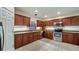 Well-lit kitchen with wooden cabinets, stainless steel appliances, and tile flooring at 16608 W Citrus Pkwy, Clermont, FL 34714