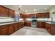 Well-lit kitchen featuring wooden cabinets, stainless steel appliances, and tile flooring at 16608 W Citrus Pkwy, Clermont, FL 34714