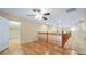 Open loft area with wood floors, a wood banister, and ample lighting with ceiling fans at 16608 W Citrus Pkwy, Clermont, FL 34714