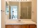 Bathroom featuring a wooden vanity with laminate countertop and large mirror at 17174 Se 76Th Caledonia Ter, The Villages, FL 32162