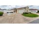 Home exterior showcasing a well-maintained driveway, lawn, and landscaping at 17174 Se 76Th Caledonia Ter, The Villages, FL 32162