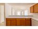 View of kitchen counter with wooden cabinets and open view to the living room at 17174 Se 76Th Caledonia Ter, The Villages, FL 32162