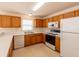 Functional kitchen with white appliances and light-colored wood cabinets at 17174 Se 76Th Caledonia Ter, The Villages, FL 32162