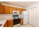 Bright kitchen features wooden cabinetry, white appliances, and smooth countertops, offering both functionality and style at 17174 Se 76Th Caledonia Ter, The Villages, FL 32162