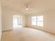 Spacious living room with a ceiling fan and natural light, seamlessly connecting to the outdoor area at 17174 Se 76Th Caledonia Ter, The Villages, FL 32162