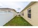 Side yard with healthy green grass and a walkway, connecting the front and back areas at 17174 Se 76Th Caledonia Ter, The Villages, FL 32162