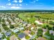 Scenic aerial shot of a home near a pristine golf course, featuring vibrant green fairways and mature trees at 1723 Townsend Ter, The Villages, FL 32162