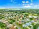 Aerial view of a residential area with homes, green spaces, golf courses, and a lake in the distance at 1723 Townsend Ter, The Villages, FL 32162