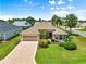 Charming single-story home with a well-maintained lawn, attached garage, and lush palm trees at 1723 Townsend Ter, The Villages, FL 32162