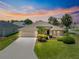 Beautiful single-story home featuring a manicured lawn, a two-car garage, and mature palm trees at 1723 Townsend Ter, The Villages, FL 32162