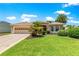 Charming front exterior with a well-manicured lawn, mature landscaping, and a two-car garage at 1723 Townsend Ter, The Villages, FL 32162