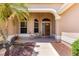 Inviting front porch with seating, decorative plants, and a charming wooden front door at 1723 Townsend Ter, The Villages, FL 32162