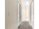 Hallway with carpet flooring and multiple doors, leading to various rooms of the house at 1723 Townsend Ter, The Villages, FL 32162