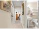Hallway view to a bathroom featuring a pedestal sink and toilet; leads to bedroom, offering convenience and style at 1723 Townsend Ter, The Villages, FL 32162