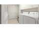 Bright laundry room with white washer and dryer, tile flooring, and ample cabinet space for storage at 1723 Townsend Ter, The Villages, FL 32162