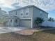 View of home featuring an attached two-car garage, a well-manicured lawn, and minimal landscaping at 1730 Ridgemoor Dr, Mascotte, FL 34753