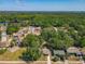 Aerial view of a neighborhood with houses surrounded by lush greenery and a lake in the distance at 1905 Selleen Dr, Eustis, FL 32726