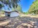 View of the backyard with trash bins and a chain-link fence with a playground visible in the distance at 1905 Selleen Dr, Eustis, FL 32726