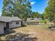 View of the backyard with a chain-link fence, a small patio, and a playground in the distance at 1905 Selleen Dr, Eustis, FL 32726