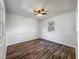 Bright bedroom featuring wood-look floors, a ceiling fan, and a window for natural light at 1905 Selleen Dr, Eustis, FL 32726